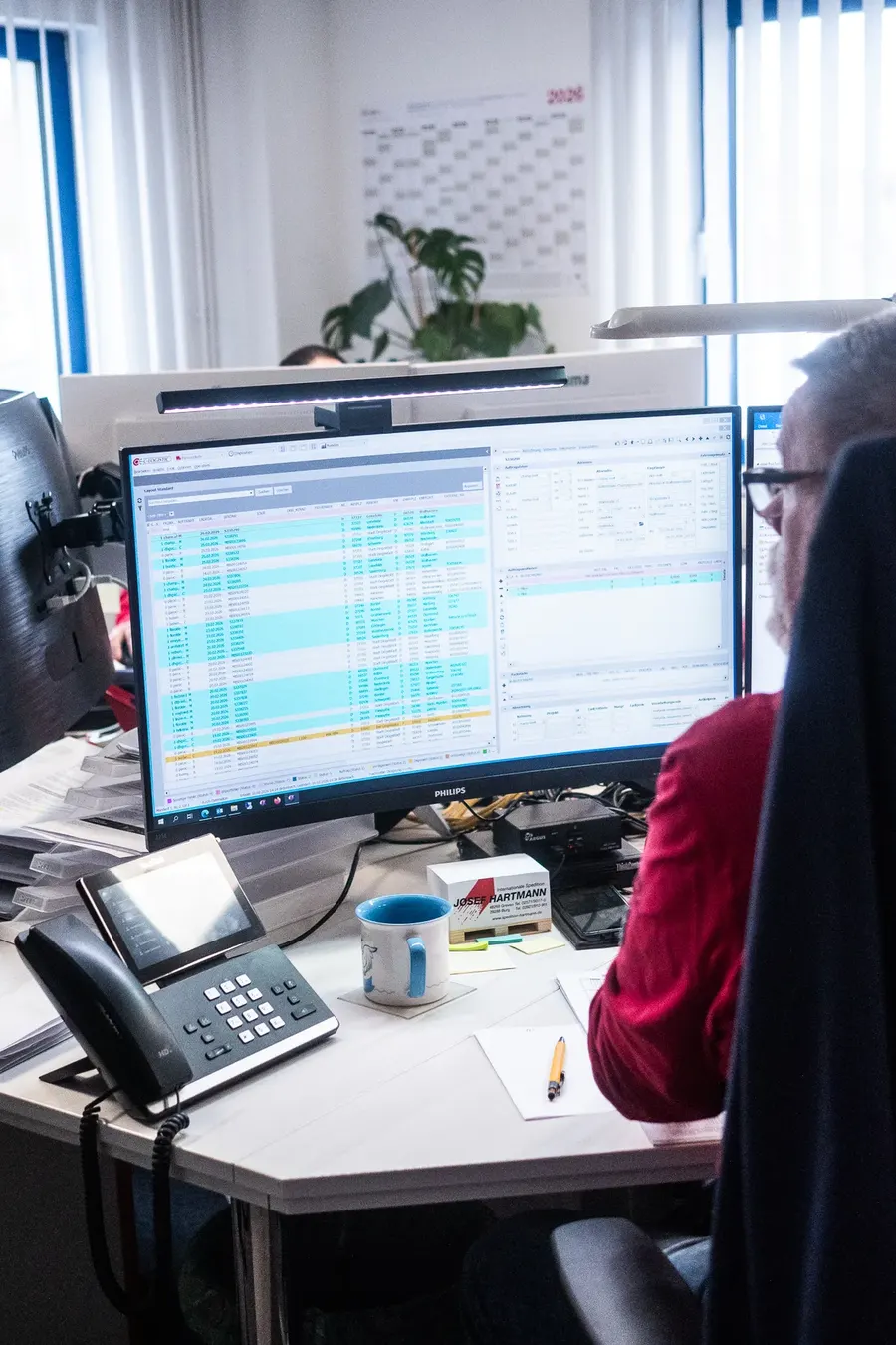 Arbeitsplatz mit Speditionssoftware und Tourenliste auf dem Monitor