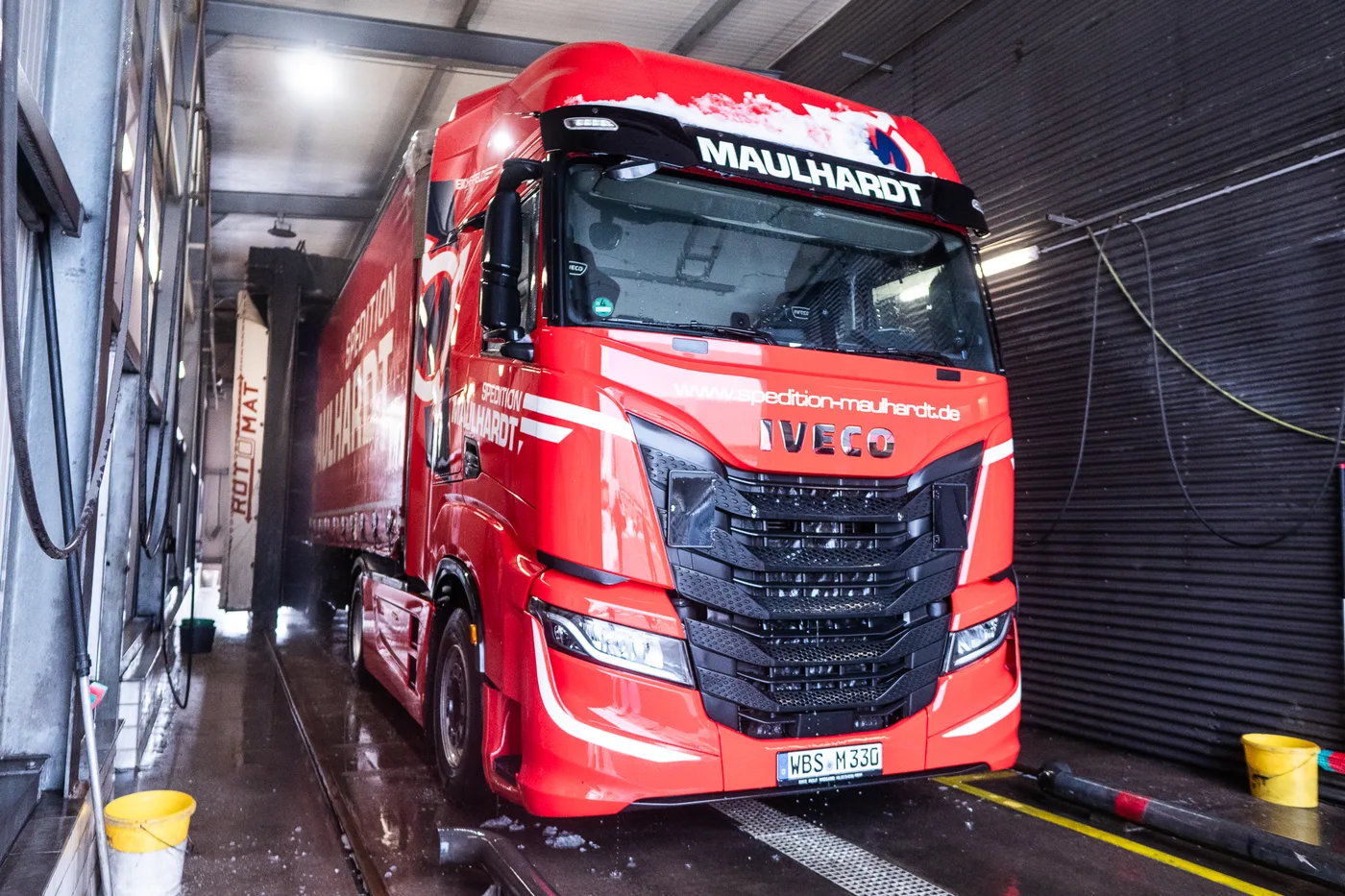 Kompletter Sattelzug mit Auflieger steht in der Waschgasse der LKW-Waschstraße
