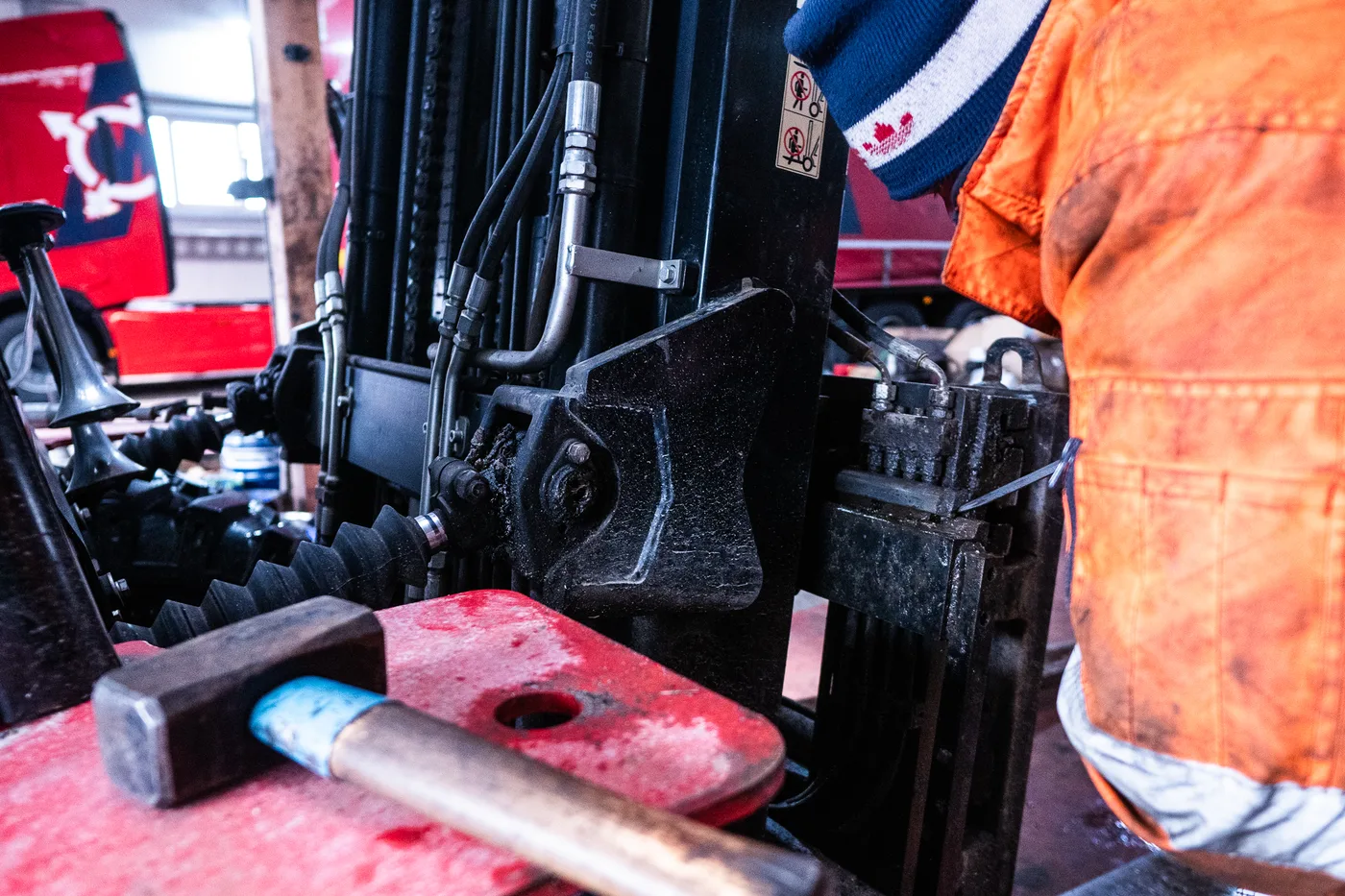 Mechaniker arbeitet am Hubmast eines Mitnahmestaplers in der Maulhardt-Werkstatt